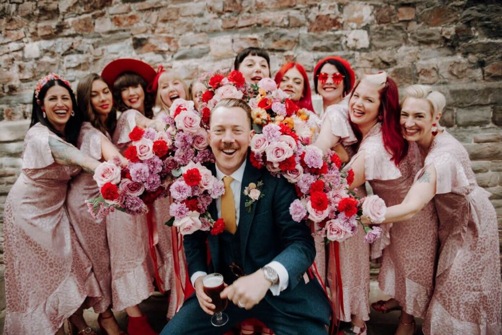Groom and Bridesmaids with pink and red flowers